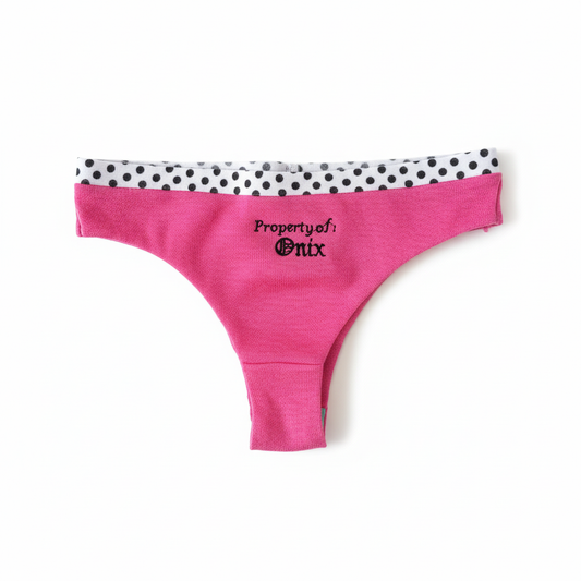 Flat lay of hot pink personalized embroidered underwear with polka dot waistband