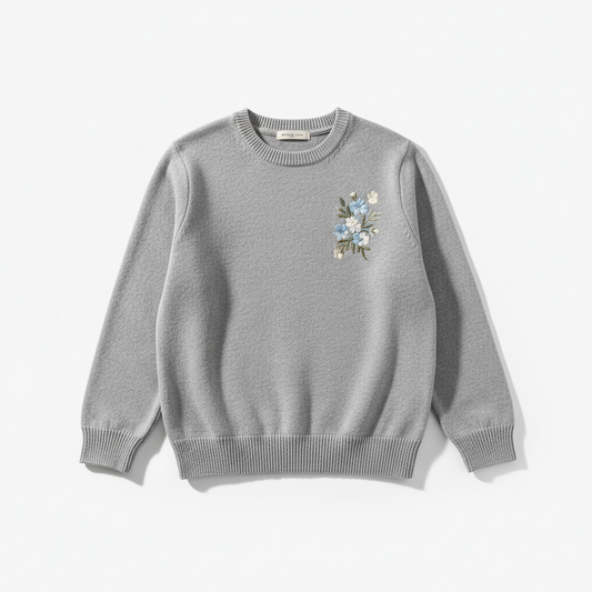Grey crew neck sweater with embroidered floral design on right chest, flat lay on white background