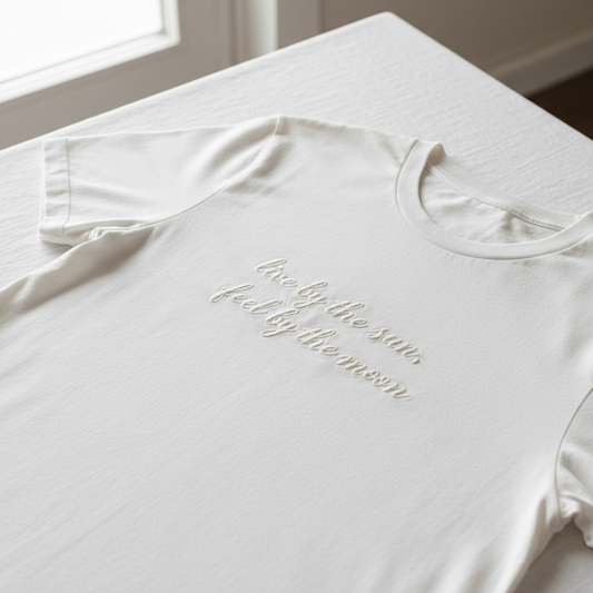 Flat lay of personalized embroidered t-shirt on white surface